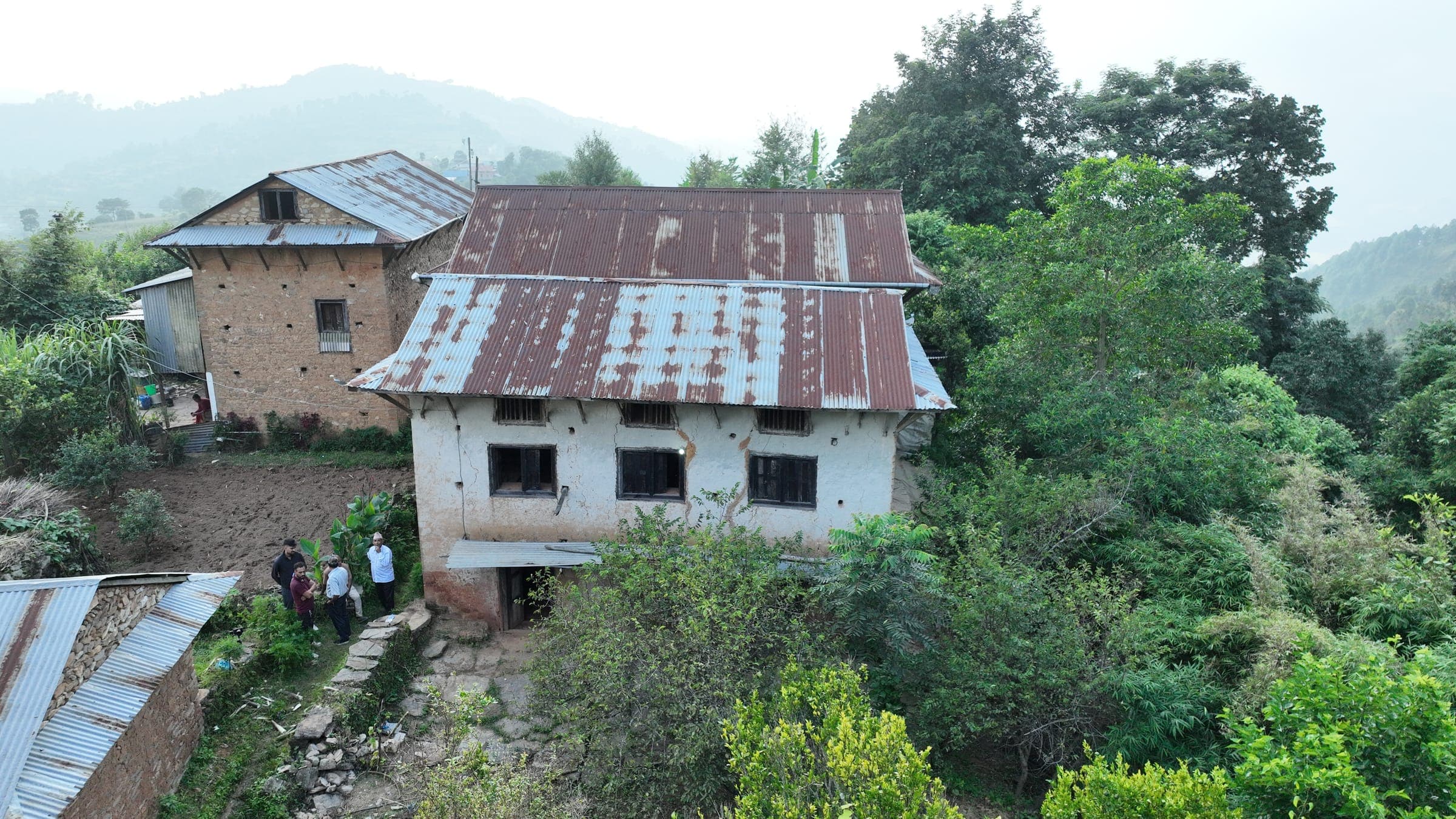 The old white house in Thumka, half swallowed by trees, on the first day of work